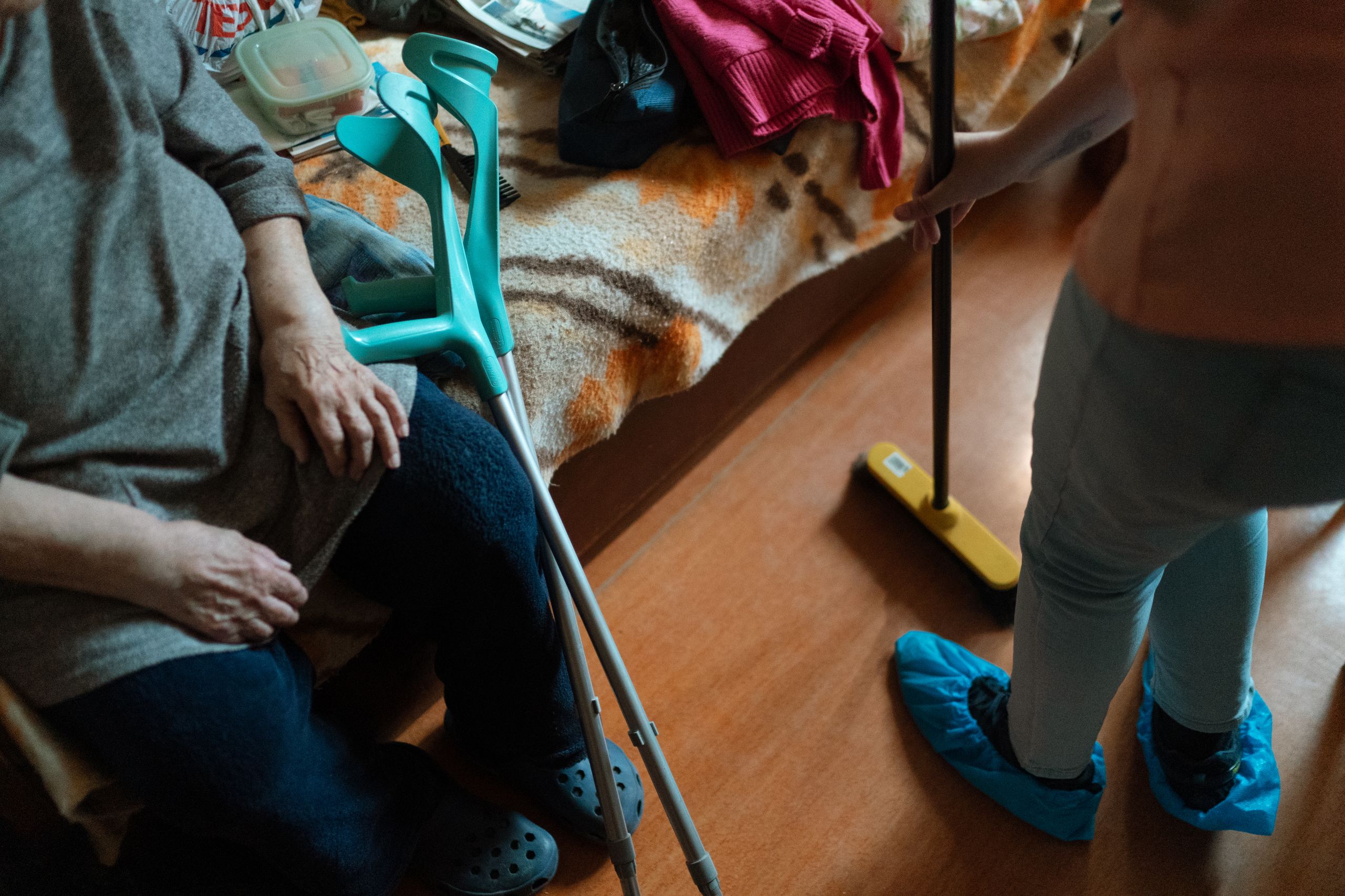 Notre résidence Caregiver helps an elderly woman with cleaning tasks, showcasing home care support.